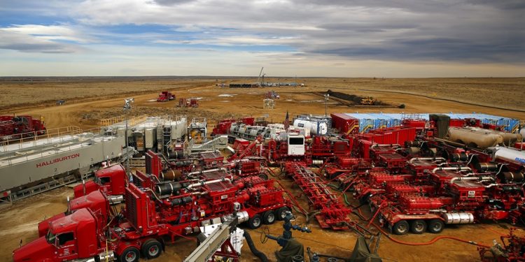 A Halliburton frac team sits idle in the foreground as a coil using operation takes place in the distance on Noble Energy's Wells Ranch operation in Weld County, Colorado, March 26, 2013.